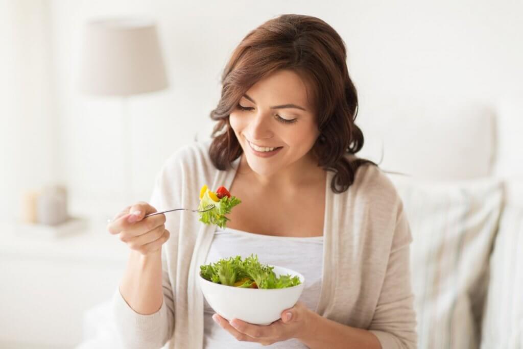 Mulher comendo salada X doce
