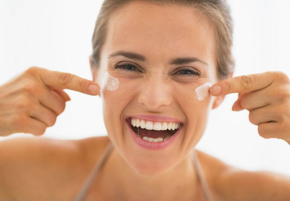 mulher passando hidratante facial