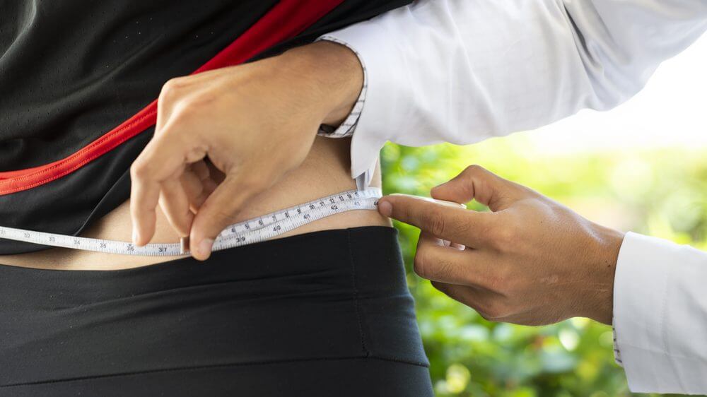 circunferência de uma pessoa sendo medida com uma fita métrica.